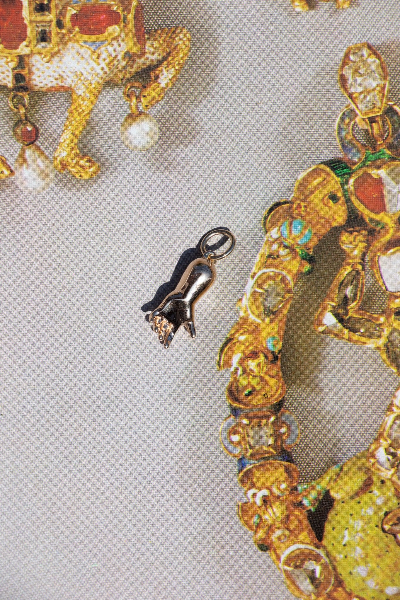 large 14k gold baby hand charm palm open on a flat background – queer and trans fine jewelry by lettuce goods / 14karatdoll